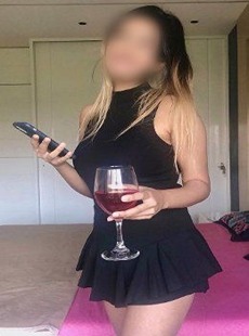 Nikita Wakad escorts models standing inside hotel room with a glass of wine